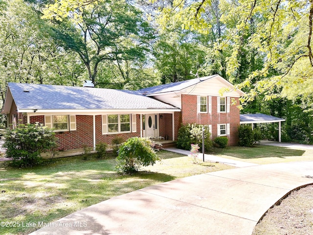 605 Noble Rd, Tallassee, AL 36078 - tri-level home featuring brick siding, driveway, a front yard, and a carport