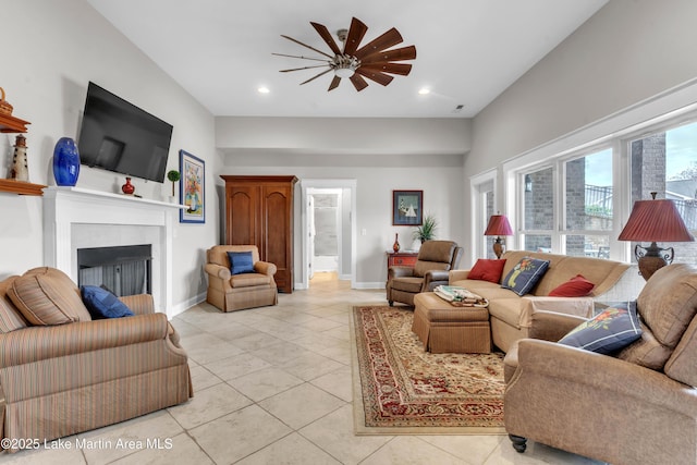 tiled living room featuring ceiling fan and a fireplace