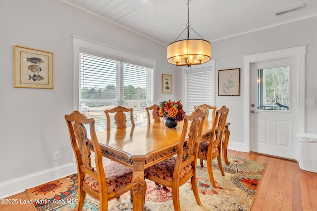 dining area featuring a notable chandelier and light wood-type flooring