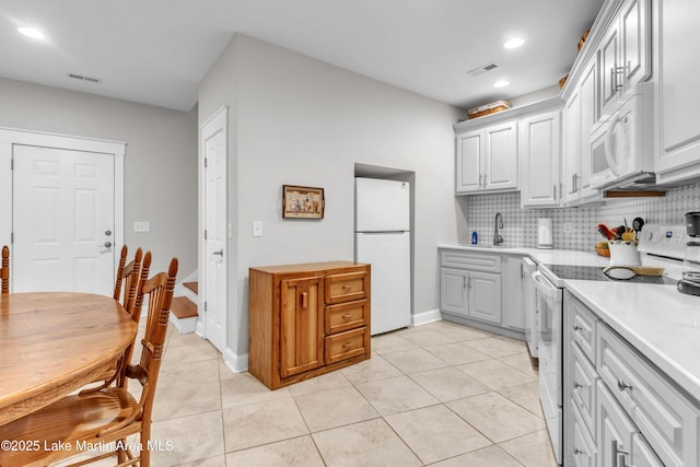 kitchen featuring sink, white appliances, decorative backsplash, and light tile patterned floors