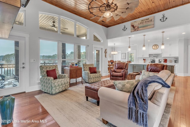 living room with light hardwood / wood-style flooring, wooden ceiling, and ceiling fan