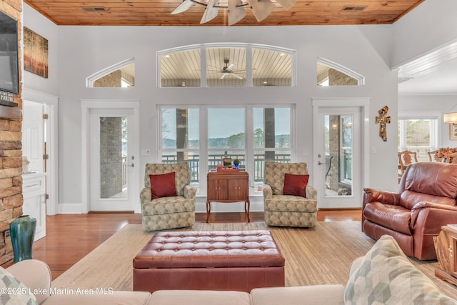 living room with wood ceiling, light hardwood / wood-style flooring, high vaulted ceiling, and ceiling fan