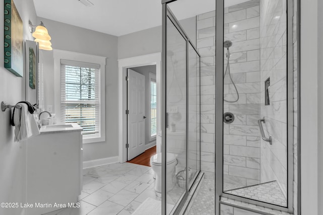 bathroom with walk in shower, vanity, and toilet