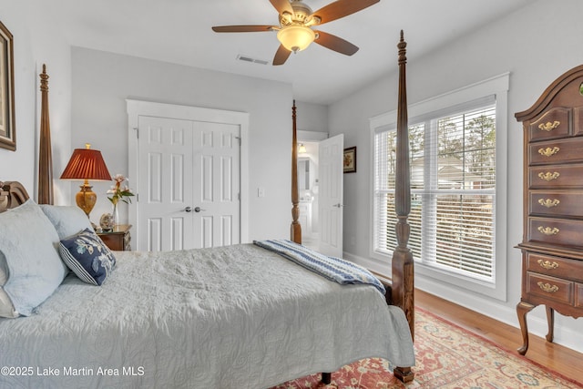 bedroom with hardwood / wood-style floors, ceiling fan, and a closet