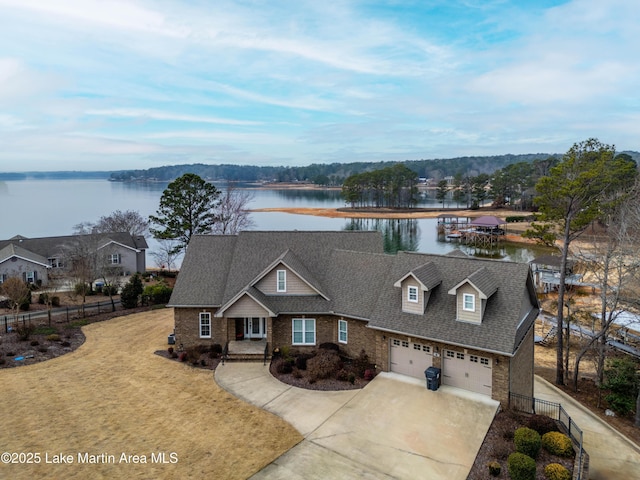 view of front facade featuring a garage, a front yard, and a water view