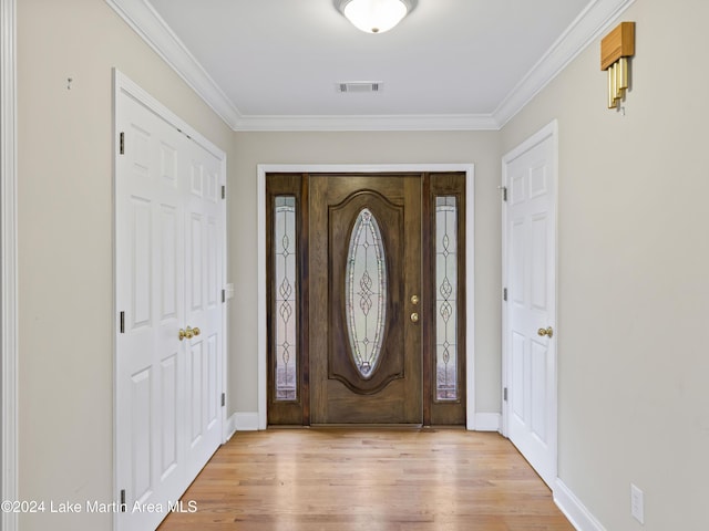 foyer entrance with ornamental molding and light hardwood / wood-style flooring