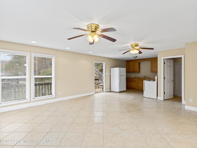 unfurnished living room with sink, ceiling fan, and light tile patterned flooring