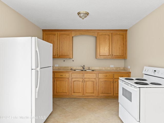 kitchen with a textured ceiling, sink, and white appliances