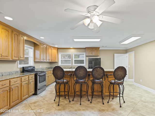 kitchen with black appliances, a center island, and light stone counters