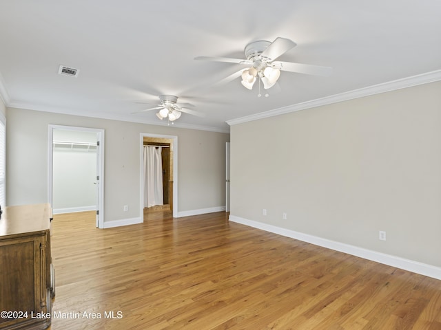 spare room with light wood-type flooring, ceiling fan, and ornamental molding