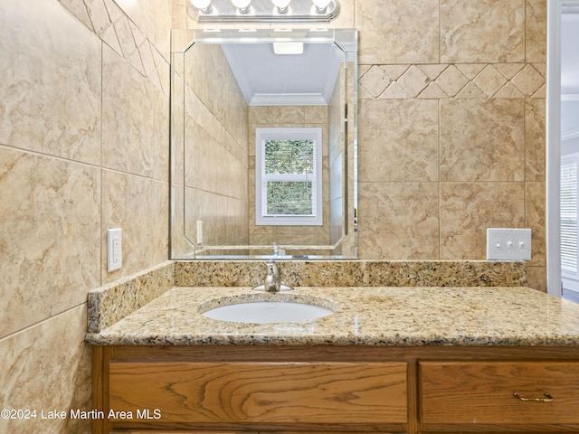 bathroom with vanity, ornamental molding, and tile walls