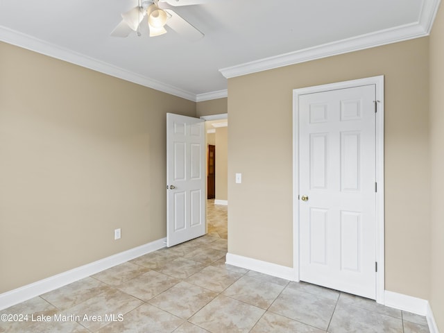 unfurnished bedroom with ceiling fan, light tile patterned flooring, crown molding, and a closet