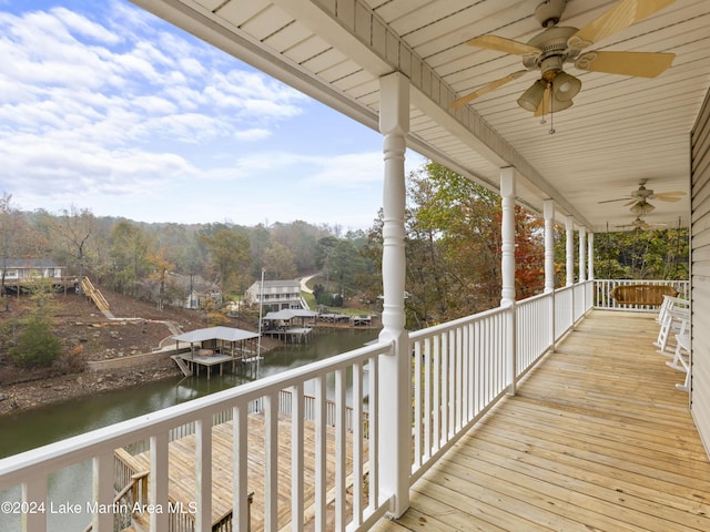 deck with a water view and ceiling fan