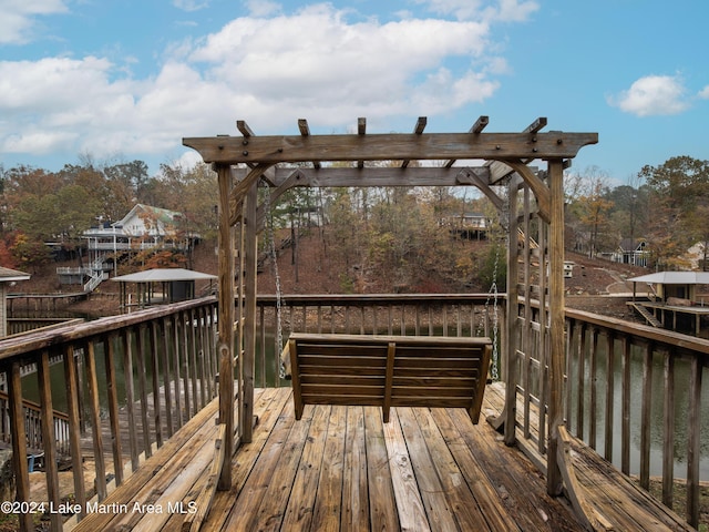 wooden terrace featuring a water view and a pergola