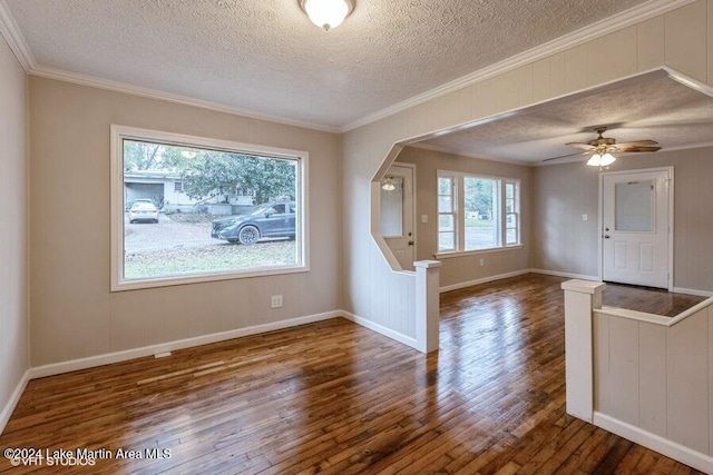 interior space featuring ceiling fan, dark wood-type flooring, a textured ceiling, and ornamental molding