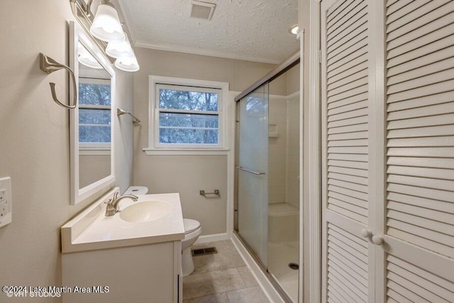 bathroom featuring a textured ceiling, vanity, a shower with door, tile patterned flooring, and toilet