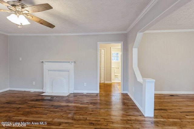 unfurnished living room with a textured ceiling, ornamental molding, and dark wood-type flooring