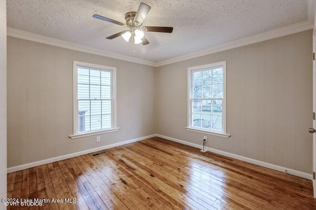 spare room with plenty of natural light, ornamental molding, and hardwood / wood-style flooring