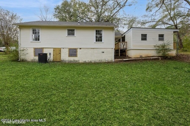 rear view of house featuring cooling unit and a yard