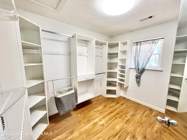 walk in closet with hardwood / wood-style floors