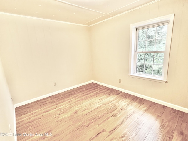 empty room featuring light hardwood / wood-style floors and ornamental molding