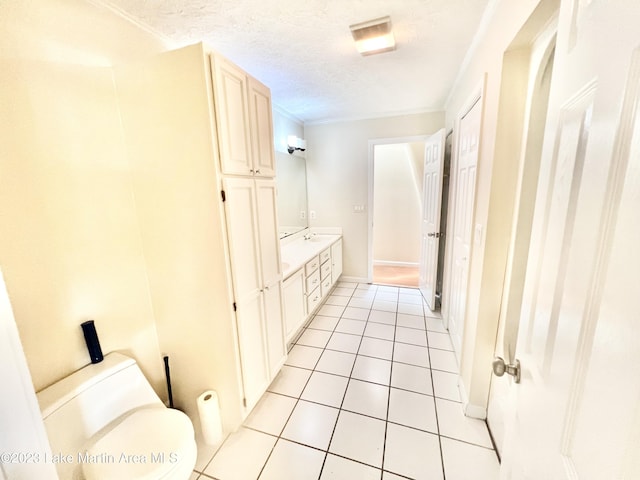 bathroom with tile patterned flooring, a textured ceiling, toilet, vanity, and ornamental molding