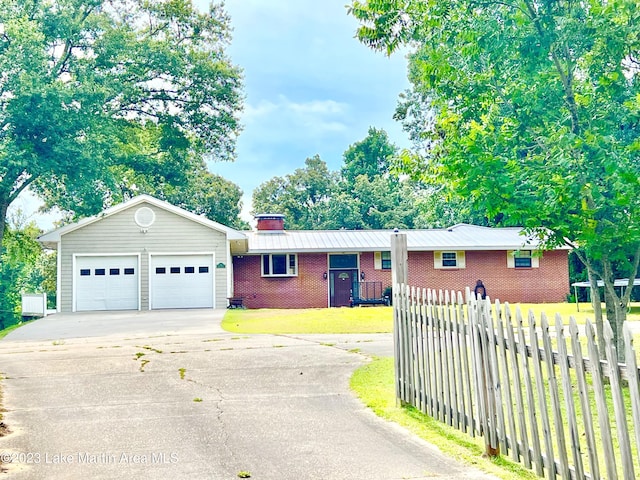 single story home with a front yard, a garage, and an outdoor structure