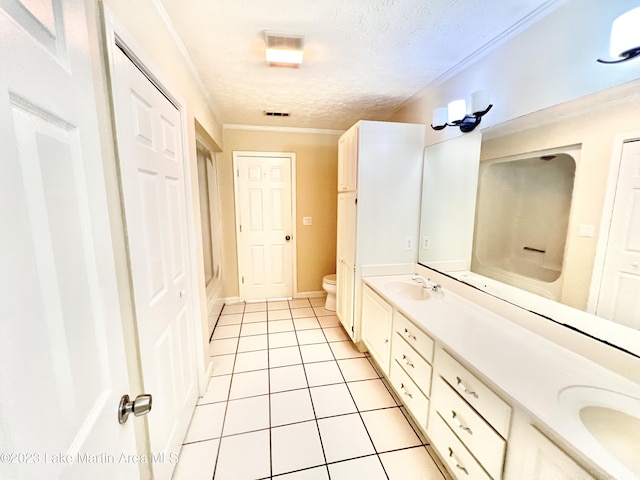 bathroom with tile patterned floors, crown molding, a textured ceiling, toilet, and vanity