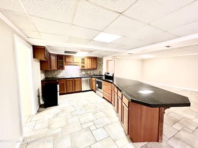 kitchen with kitchen peninsula, decorative backsplash, stainless steel appliances, and a breakfast bar area