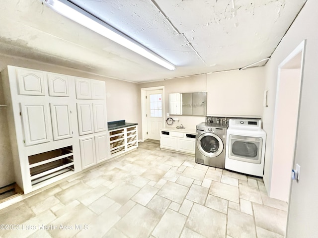 laundry room featuring washer and clothes dryer, cabinets, and sink