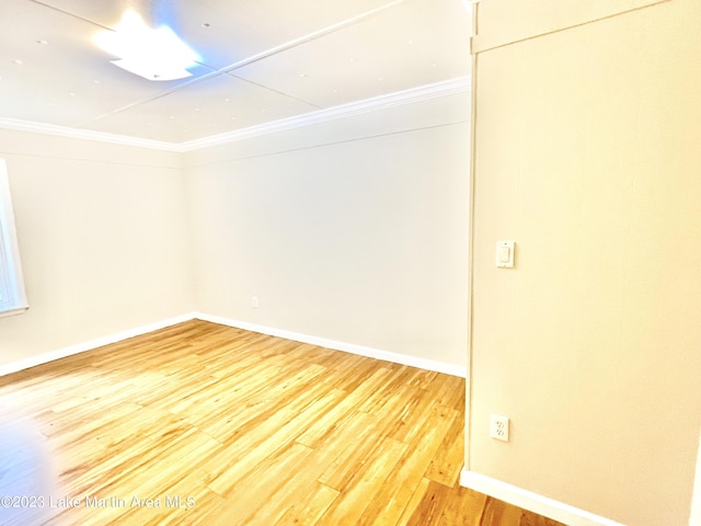 spare room with crown molding and wood-type flooring