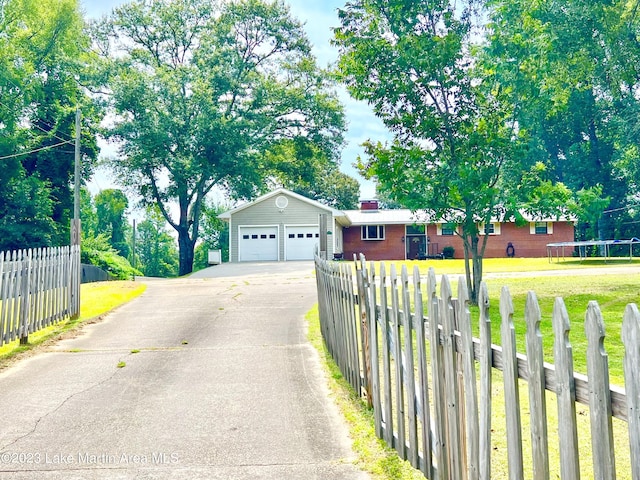 single story home featuring an outbuilding, a front lawn, and a garage