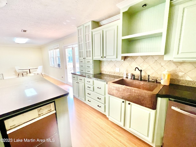 kitchen featuring dishwasher, backsplash, white cabinets, and light hardwood / wood-style flooring