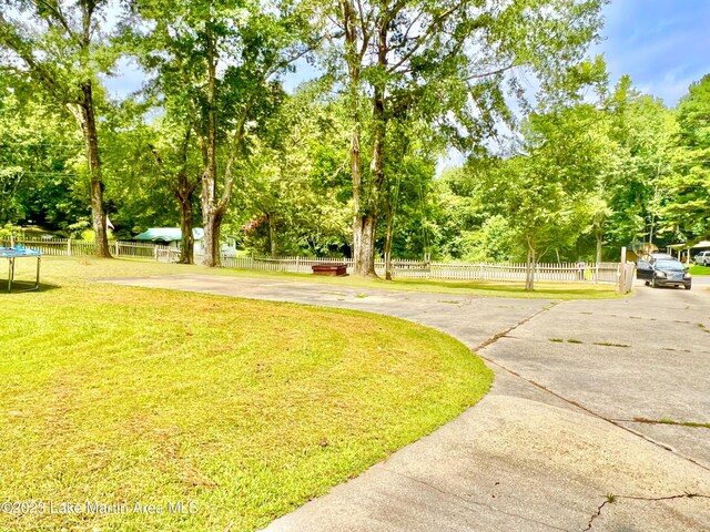 surrounding community featuring a lawn and a trampoline