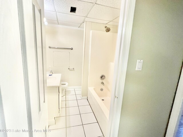 full bathroom featuring a drop ceiling, tile patterned floors, shower / bathing tub combination, toilet, and vanity