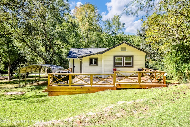 rear view of house featuring a yard and a carport