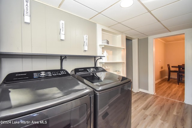 clothes washing area with independent washer and dryer and light hardwood / wood-style floors