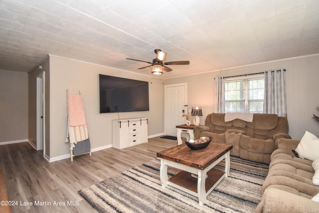 living room featuring wood-type flooring, ceiling fan, and ornamental molding