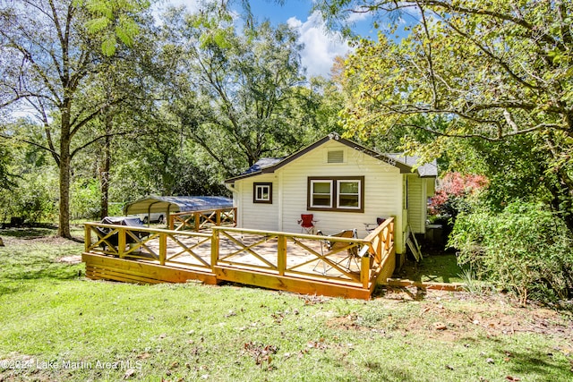 back of house featuring a carport and a lawn