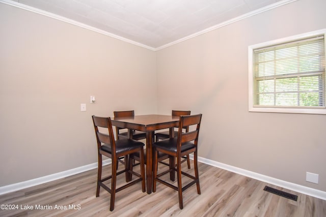 dining area featuring light hardwood / wood-style floors and ornamental molding