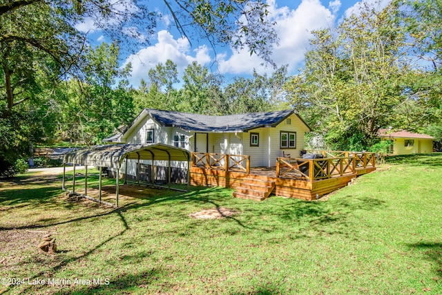 rear view of house with a deck, a carport, and a lawn