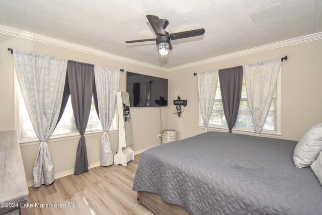 bedroom with light wood-type flooring, ceiling fan, and crown molding