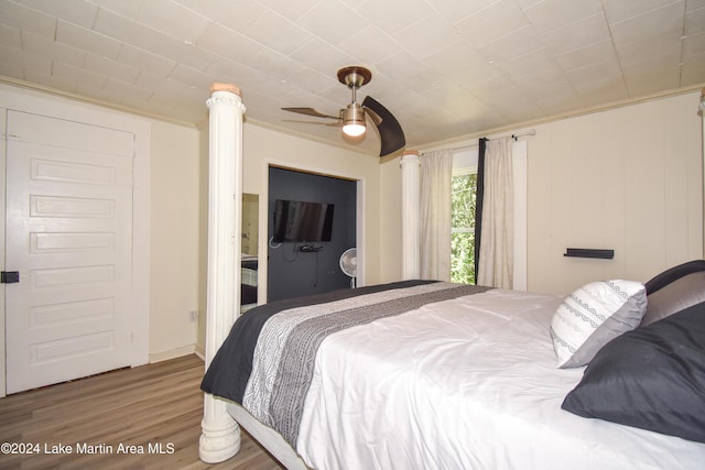 bedroom featuring ceiling fan, crown molding, and hardwood / wood-style flooring