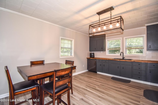 dining space featuring crown molding, wood-type flooring, and sink