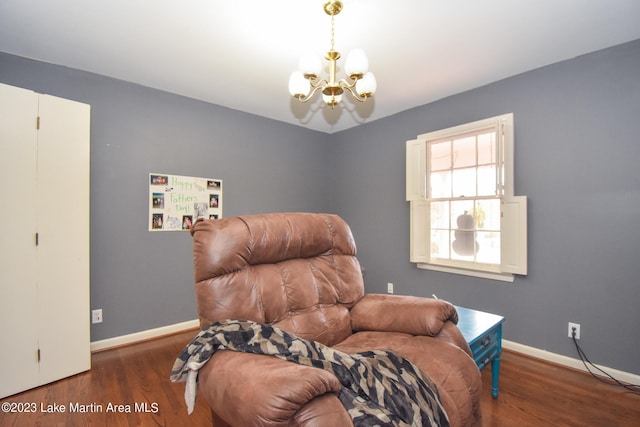 sitting room with dark wood-type flooring and a notable chandelier