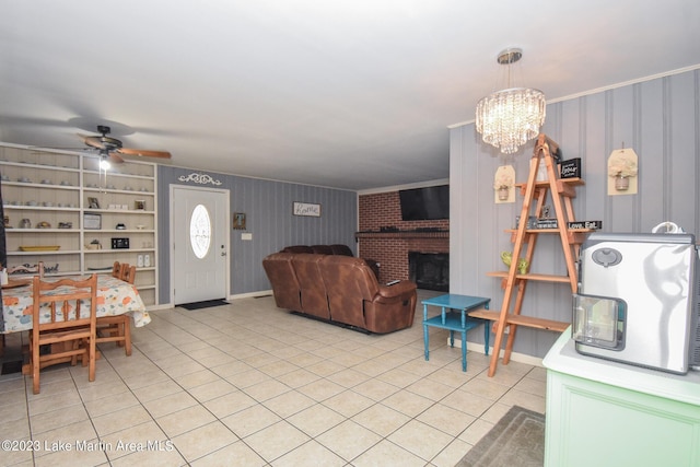 interior space featuring a fireplace, light tile patterned flooring, and ceiling fan with notable chandelier