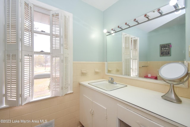 bathroom with vanity and tile walls