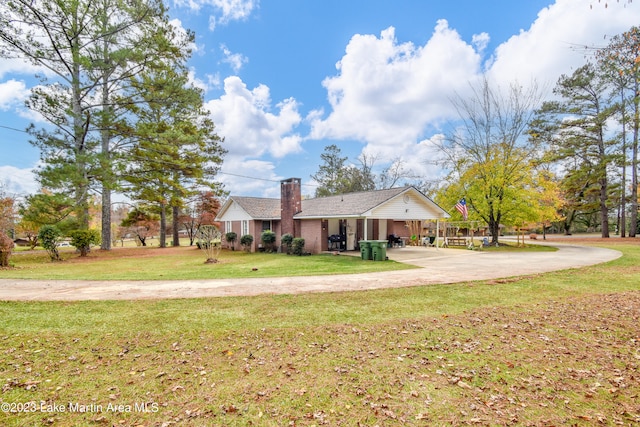 view of front of property featuring a carport and a front lawn