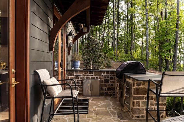 view of patio / terrace featuring a sink, outdoor wet bar, exterior kitchen, and area for grilling