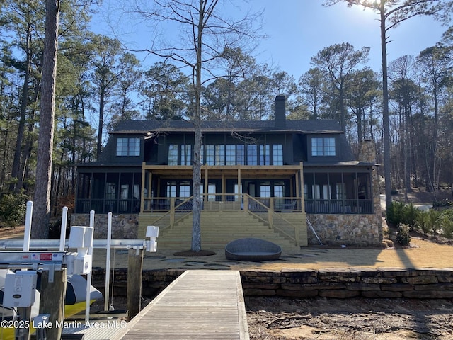 back of property featuring a sunroom, stairs, a chimney, and boat lift